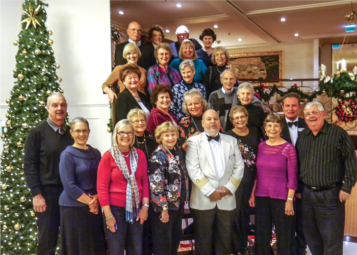 WWURA members grouped at a Holiday Event, standing next to a decorated Christmas tree.